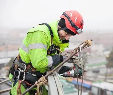 Rigger working in fall-protection equipment